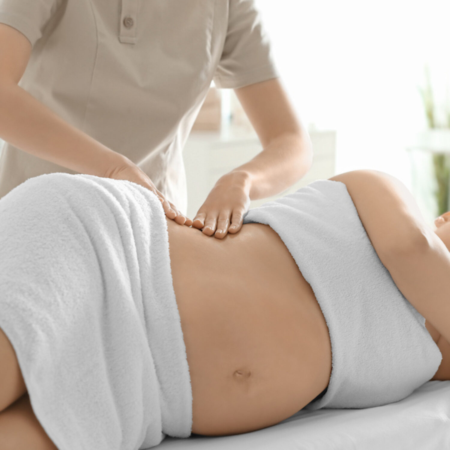 Young beautiful pregnant woman having massage in spa salon